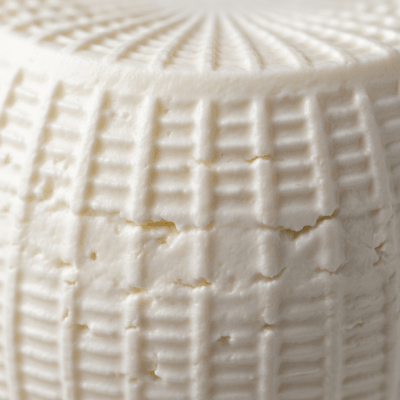 A close-up macro photograph of the rind and surface texture of a Mascarpone