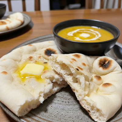 Photograph of Naan, shown being served or eaten as part of a meal