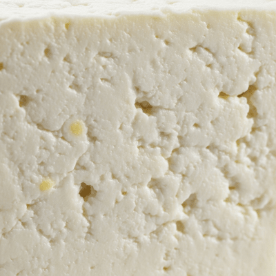 A close-up macro photograph of the rind and surface texture of a Paneer