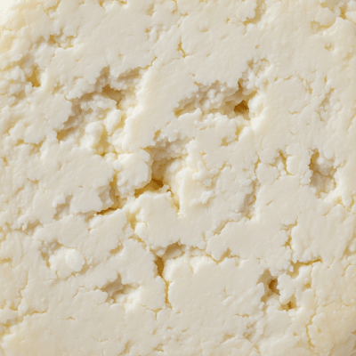 A close-up macro photograph of the rind and surface texture of a Queso Blanco