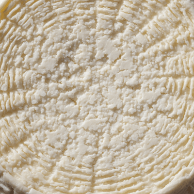 A close-up macro photograph of the rind and surface texture of a Ricotta Salata