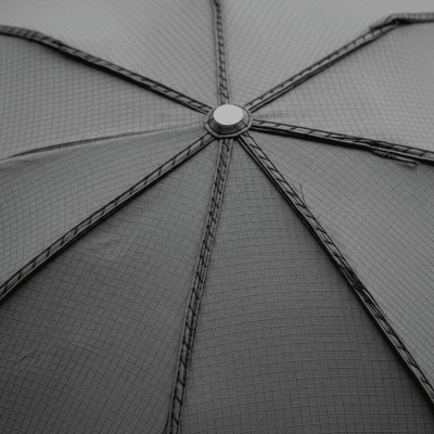 A close-up macro photograph focusing on the texture and pattern of the canopy fabric of a Windproof Umbrella (umbrellas)