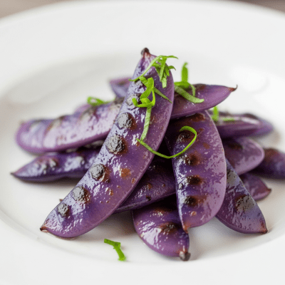 Image of cooked or prepared Wisteria (legumes) as it appears in a traditional dish or common culinary usage, presented on a clean plate with minimal garnish