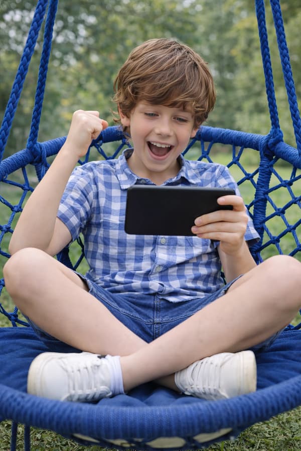 Boy cheering on a swing chair