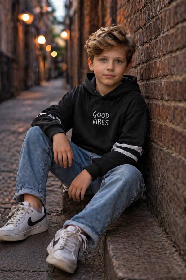Boy sitting by brick wall