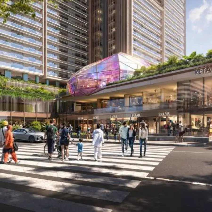 Modern twin towers with a retail area and people crossing a zebra-striped road.
