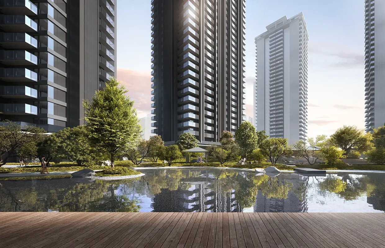 Modern residential towers beside a serene lake surrounded by lush greenery and wooden decking.