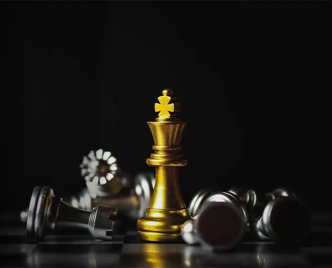 A golden king chess piece stands tall among scattered silver pieces on a dark background.