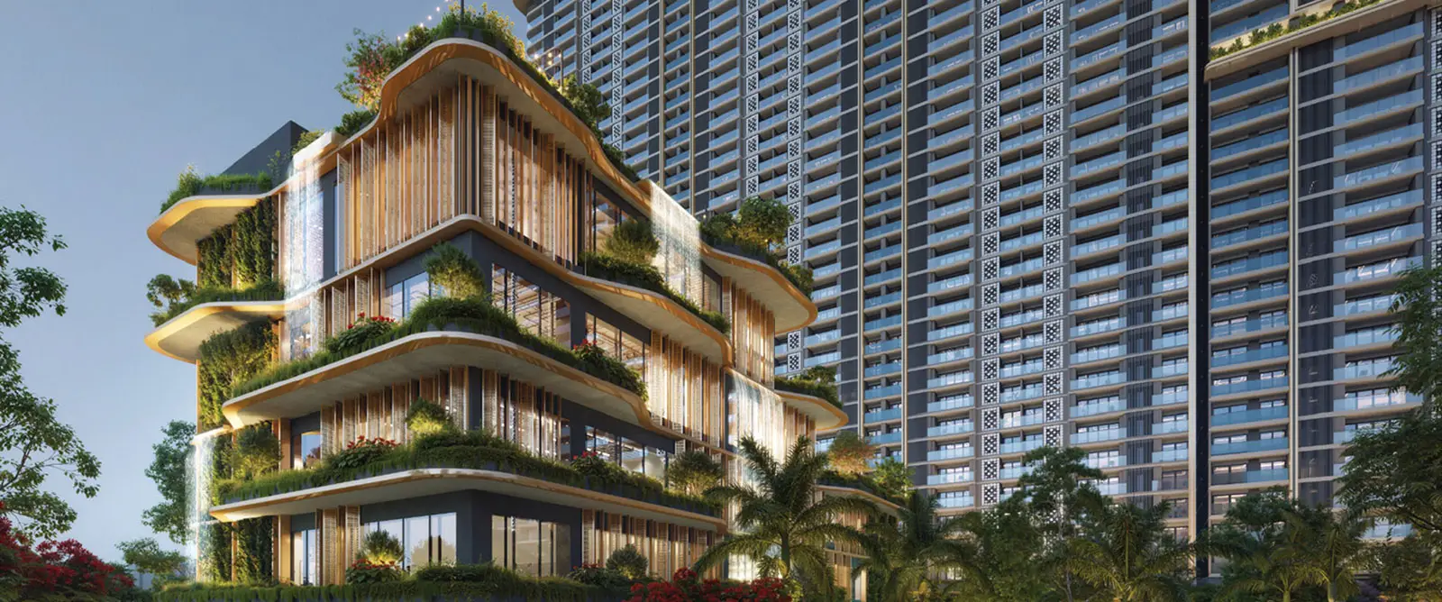 Modern building with curved design, greenery, and a tall structure in the background.