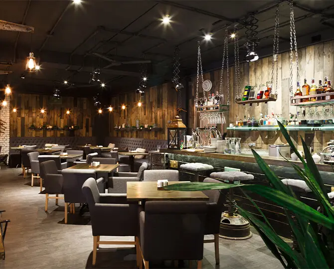 Interior of a fine dining restaurant with wooden decor, tables, and a bar area.