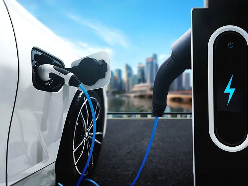 Close-up of an electric car charging port with a charging cable connected to a charging station.