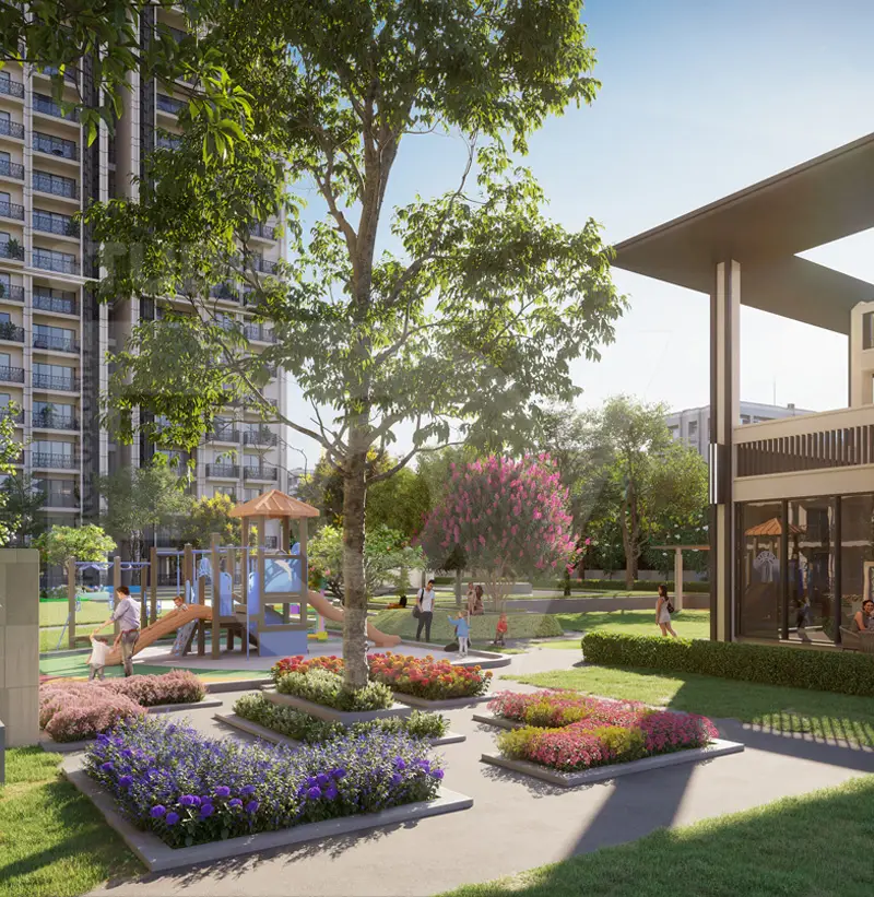 Playground with slides and climbing structures surrounded by colorful flower beds and trees.