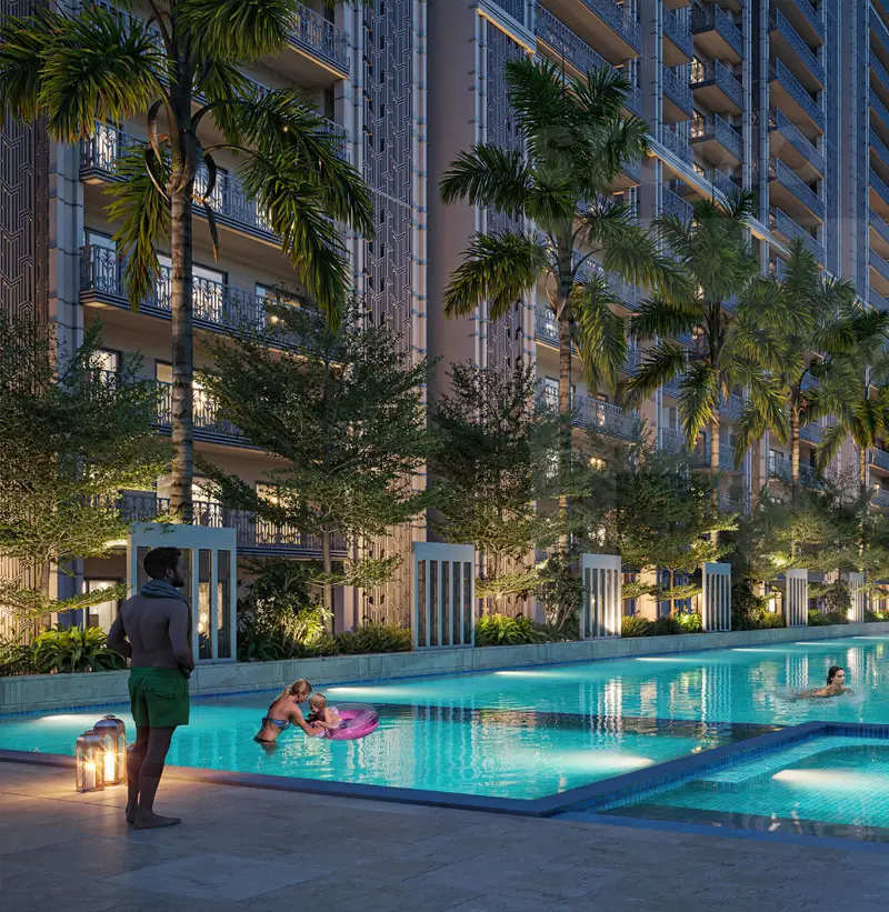 A modern swimming pool surrounded by palm trees, with people enjoying the water at night.