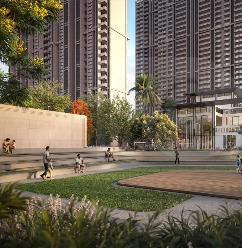 Outdoor amphitheatre with seating, greenery, and people enjoying the space near buildings.