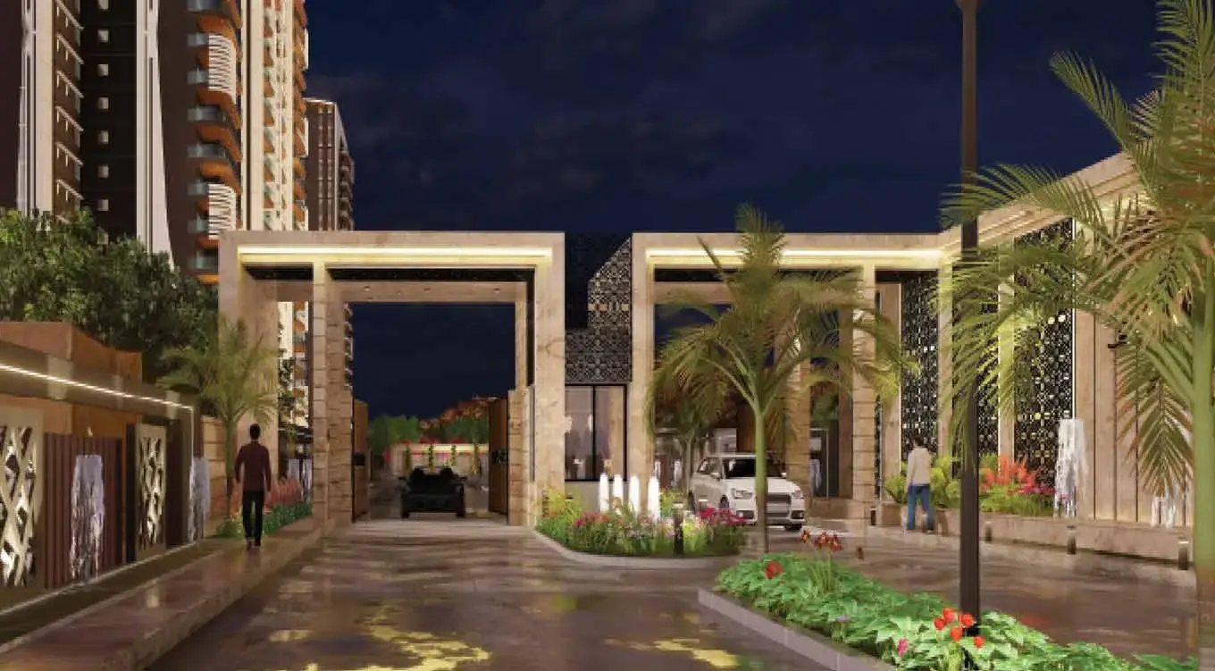 Modern entrance gate with stone arches, palm trees, and landscaped pathway at night.