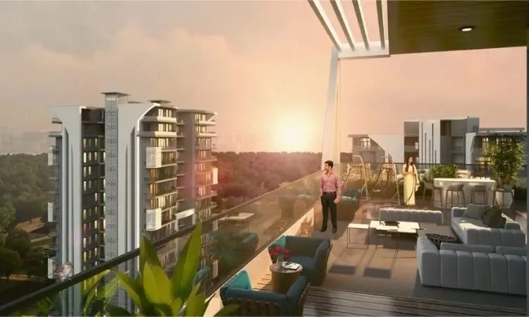 A spacious balcony with seating, overlooking a sunset and green landscape, featuring two people.