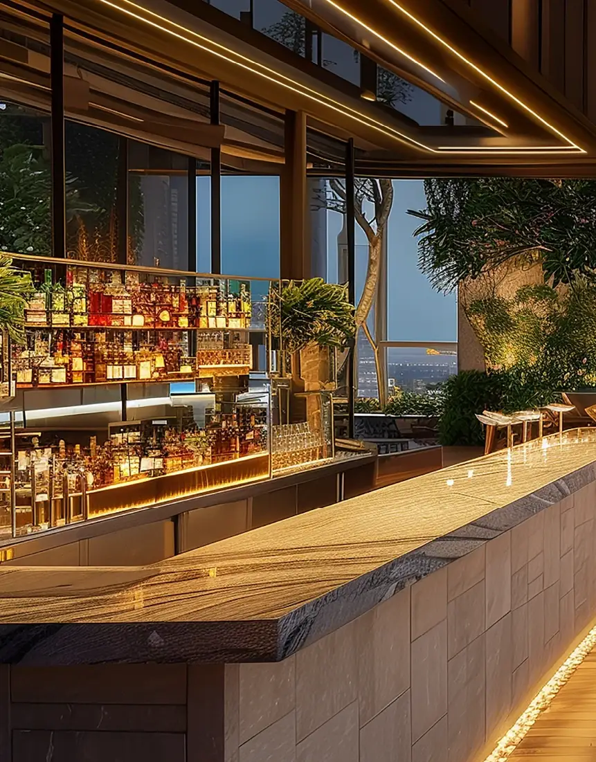 Stylish bar with illuminated shelves displaying various liquor bottles and a sleek countertop.