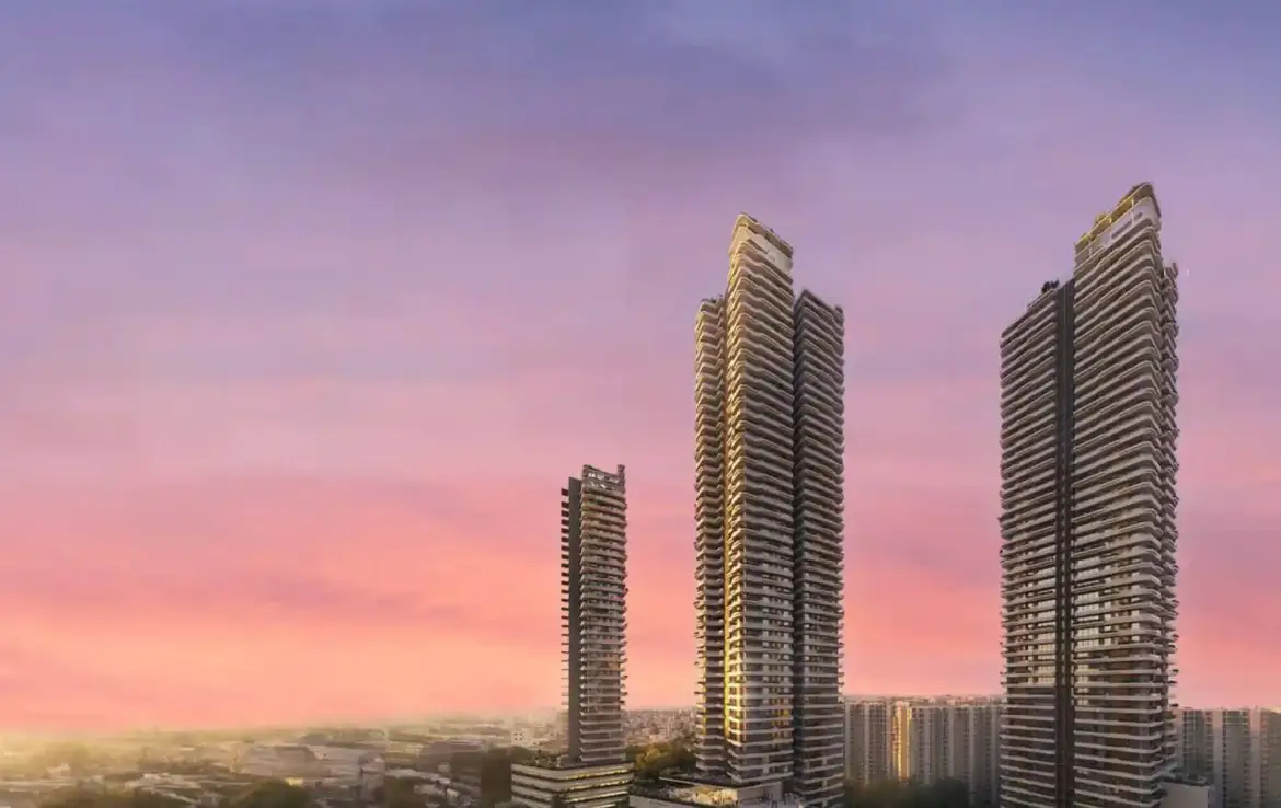 Three tall residential towers against a colorful sunset sky in Gurgaon.
