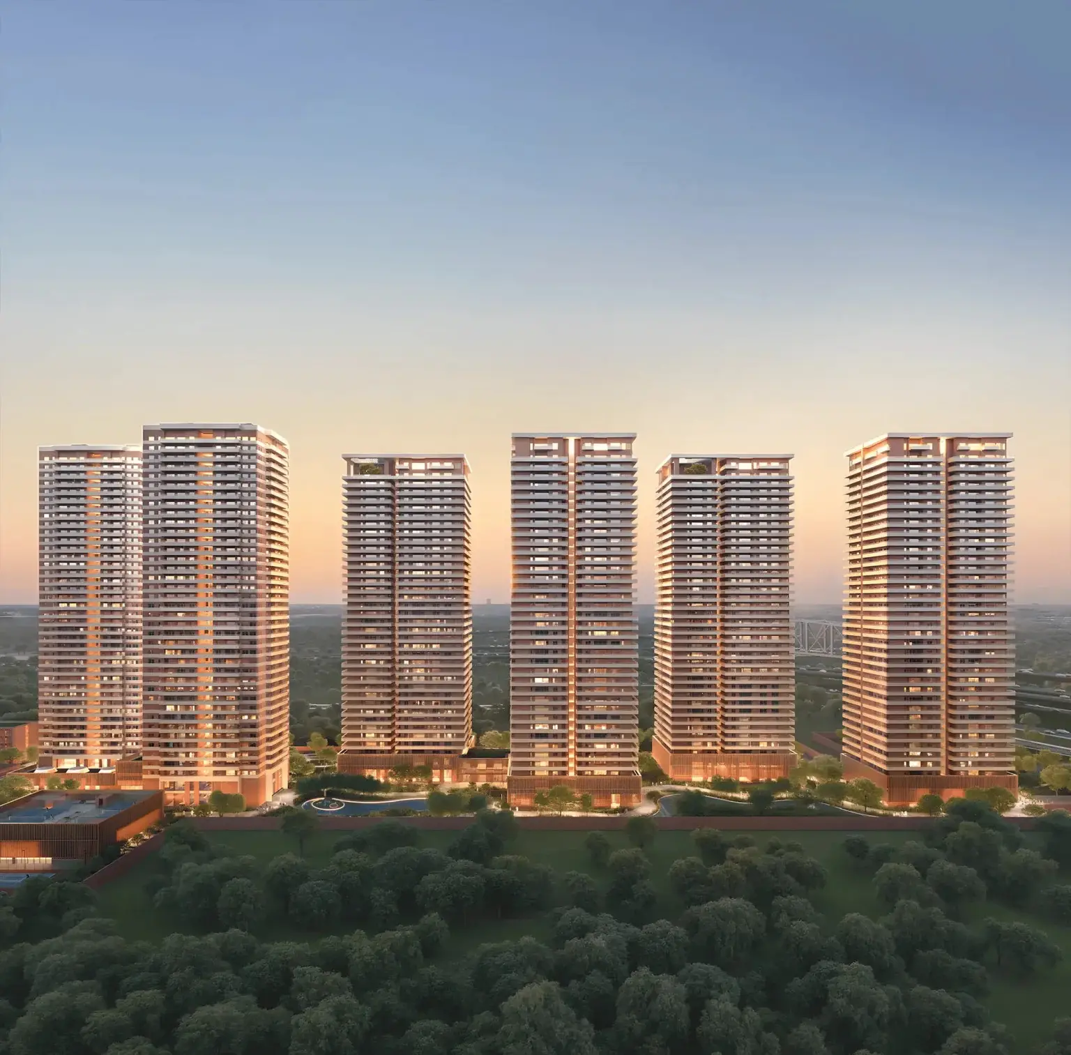Five tall residential towers with modern architecture surrounded by greenery at sunset.