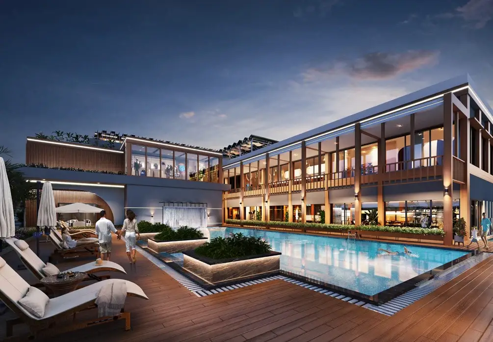 A contemporary resort with a pool, lounge chairs, and people walking towards the water.