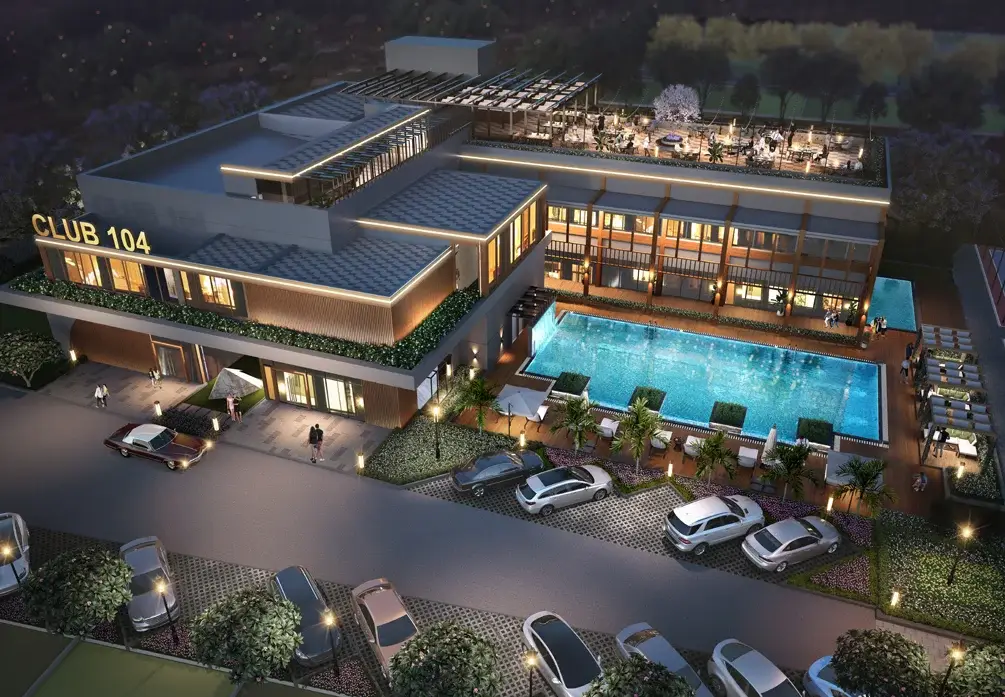 Aerial view of Club 104 featuring a pool, cars parked, and landscaped surroundings.