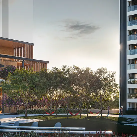 Modern building with wooden accents, green landscaping, and hammocks in a serene setting.