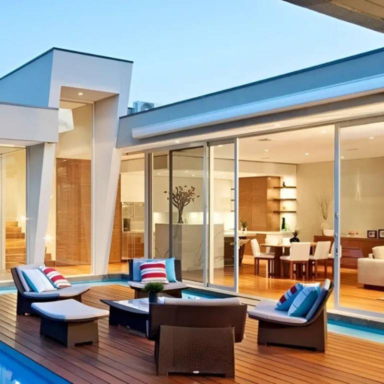 Modern outdoor sun deck with lounge chairs, table, and glass doors leading to interior space.