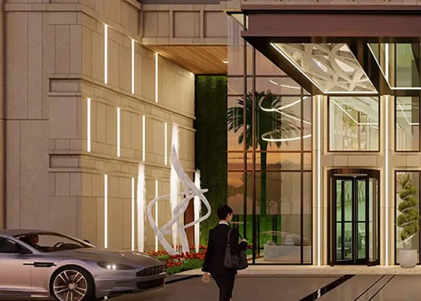 Modern building entrance with glass doors, decorative lighting, and a person walking by.