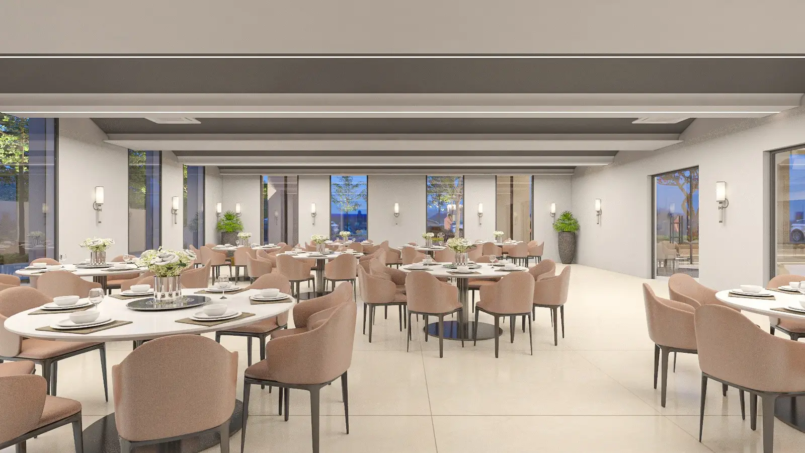 Spacious dining area with round tables, beige chairs, and large windows showing greenery outside.