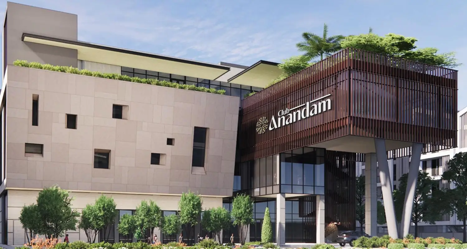 Modern building with unique facade, greenery on roof, and large glass entrance.