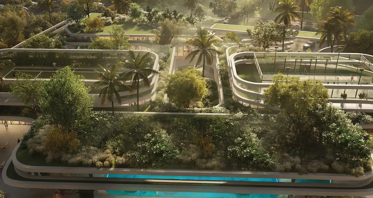 Aerial view of landscaped buildings with greenery and palm trees, featuring curved structures and pathways.