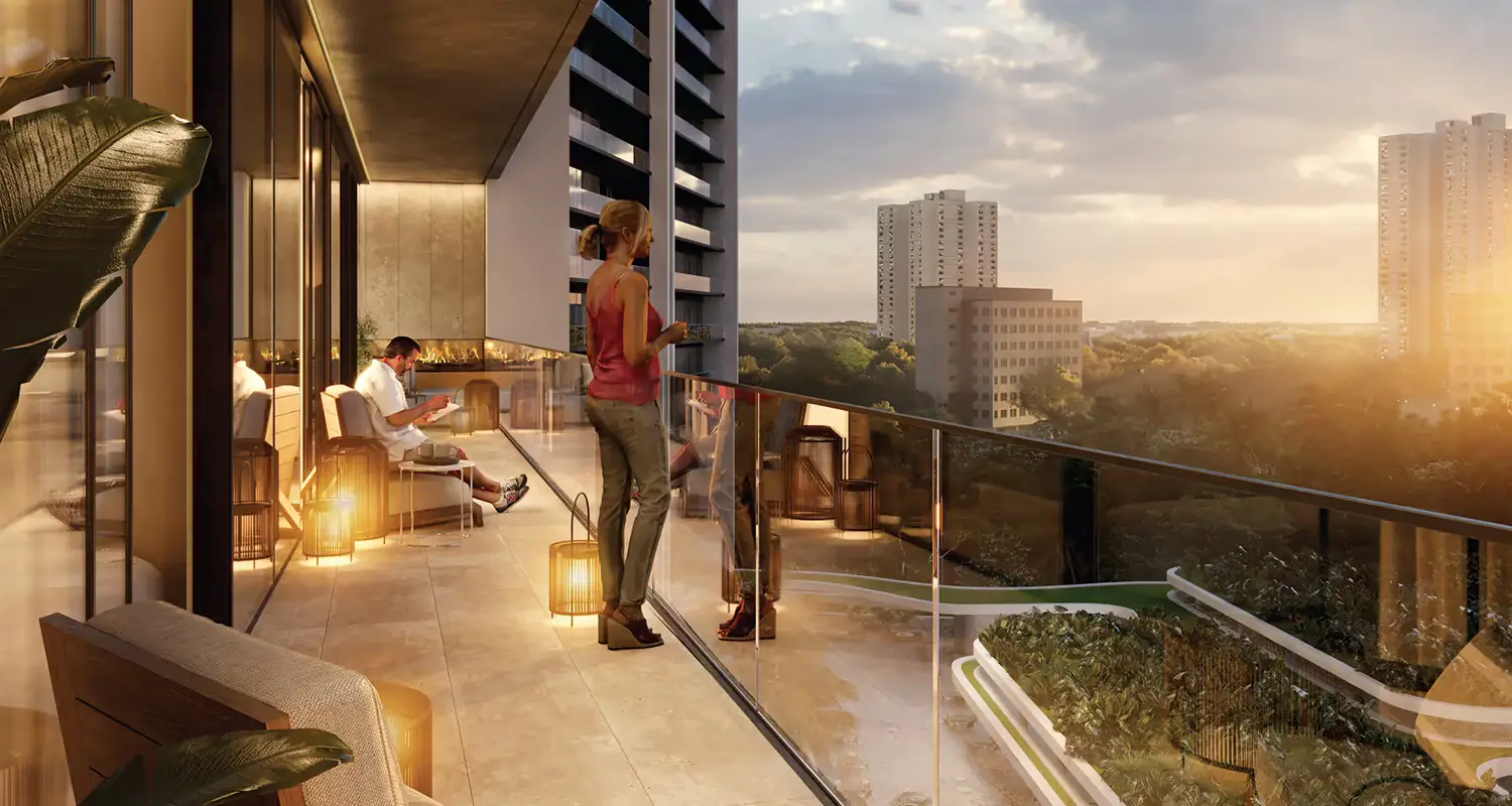People relaxing on a balcony with modern furniture, overlooking a cityscape at sunset.