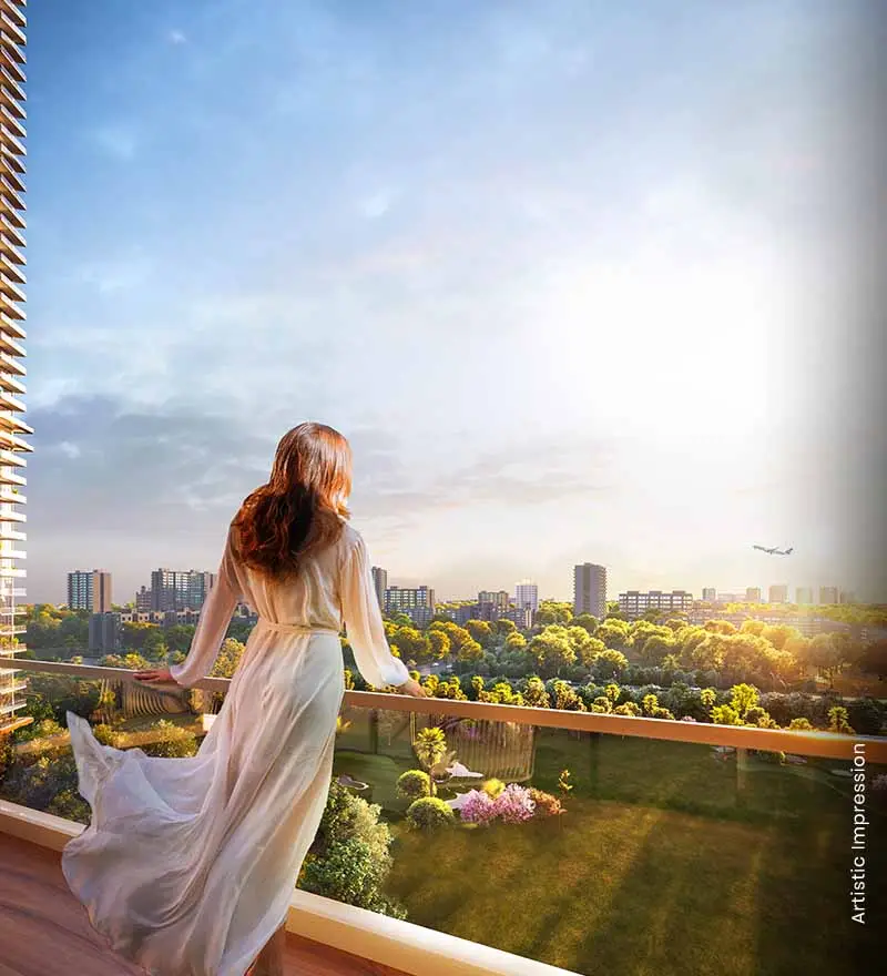 A woman in a flowing dress stands on a balcony overlooking a lush green landscape and city skyline.
