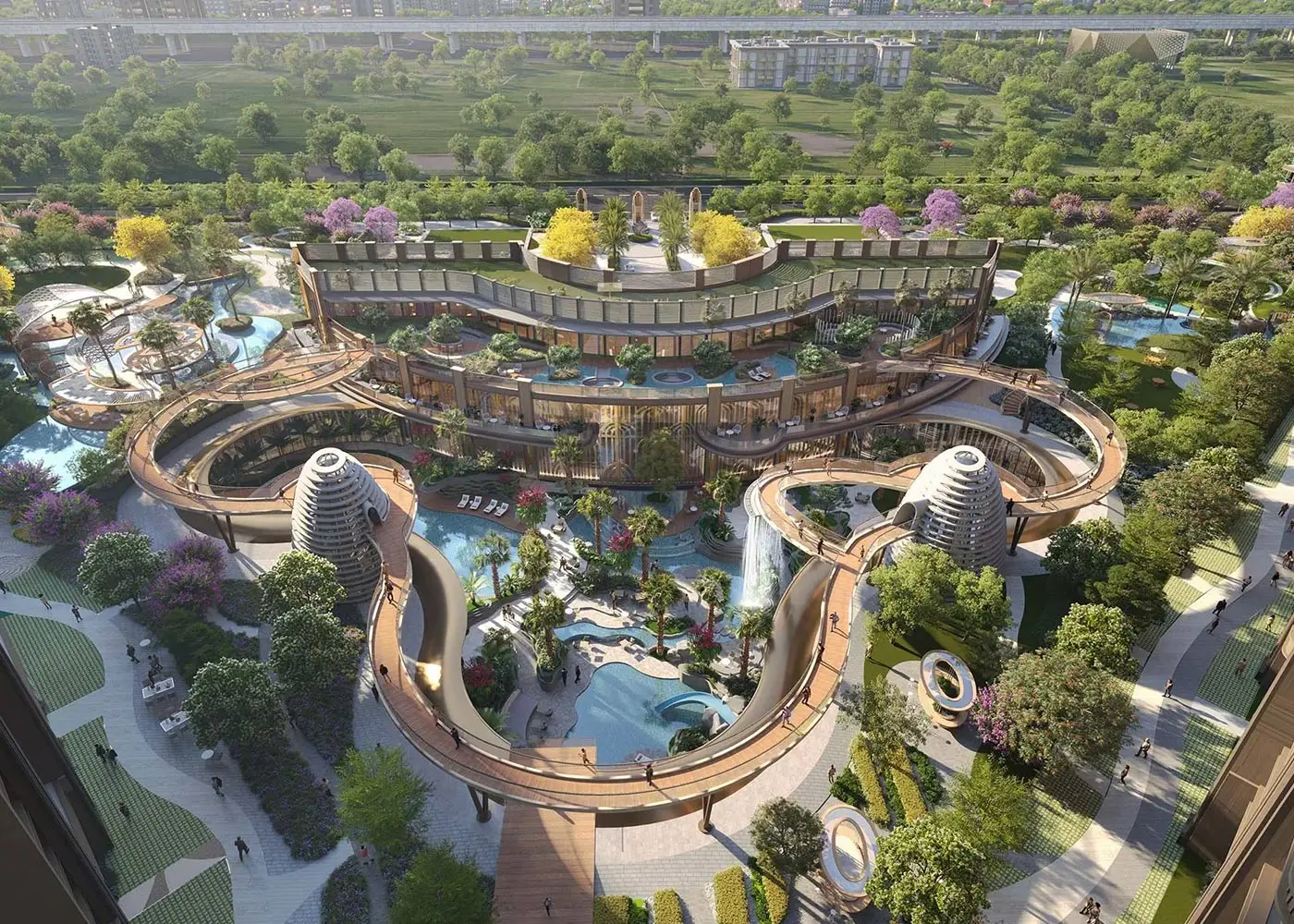 Aerial view of a landscaped resort featuring pools, waterfalls, and green spaces with colorful trees.