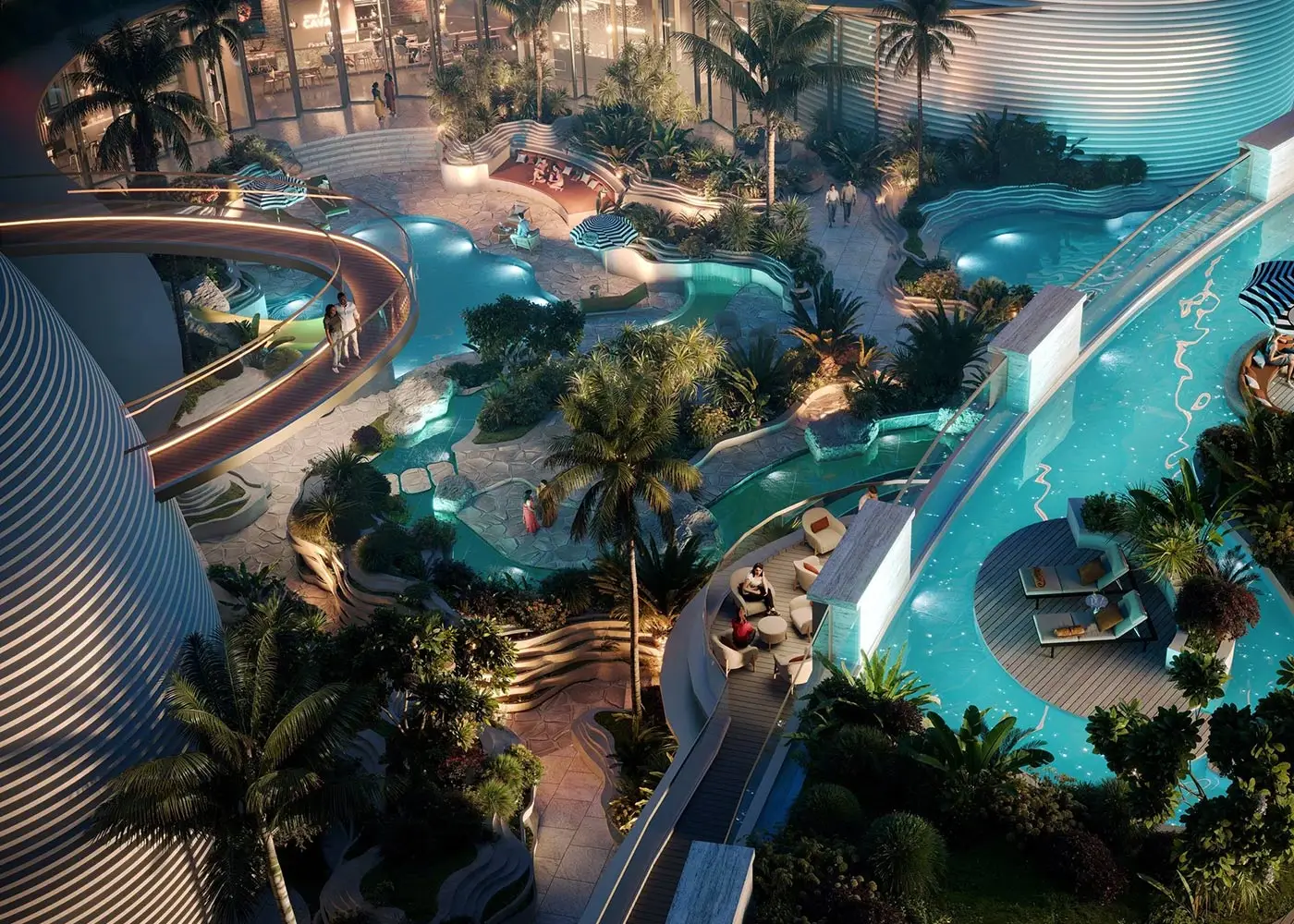 Aerial view of multiple swimming pools surrounded by lush greenery and lounge areas.