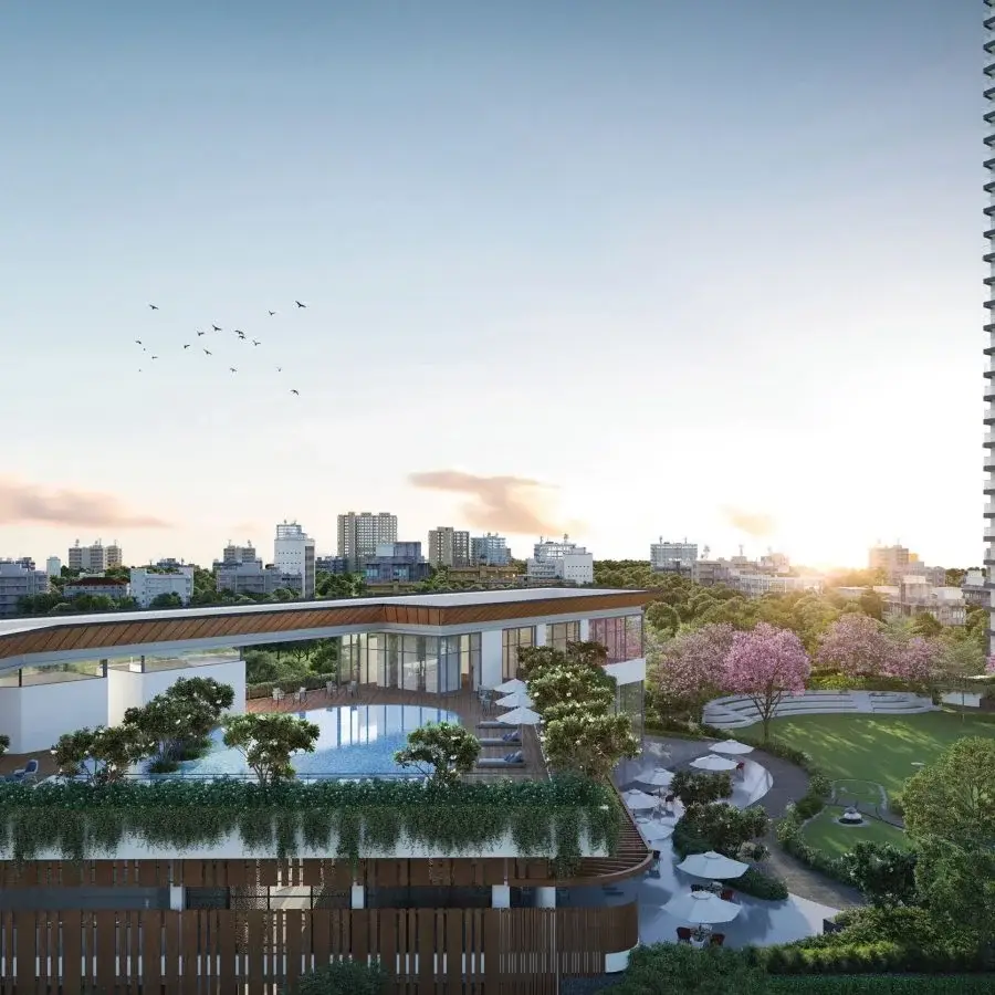 Modern building with a pool, surrounded by greenery and city skyline at sunset.