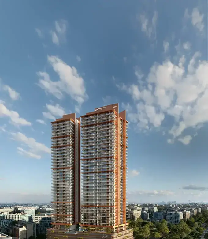 Two tall residential towers with balconies under a blue sky with scattered clouds