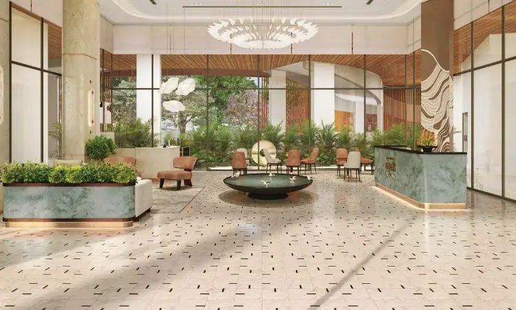 Modern lobby featuring a circular fountain, green plants, and stylish seating arrangements.