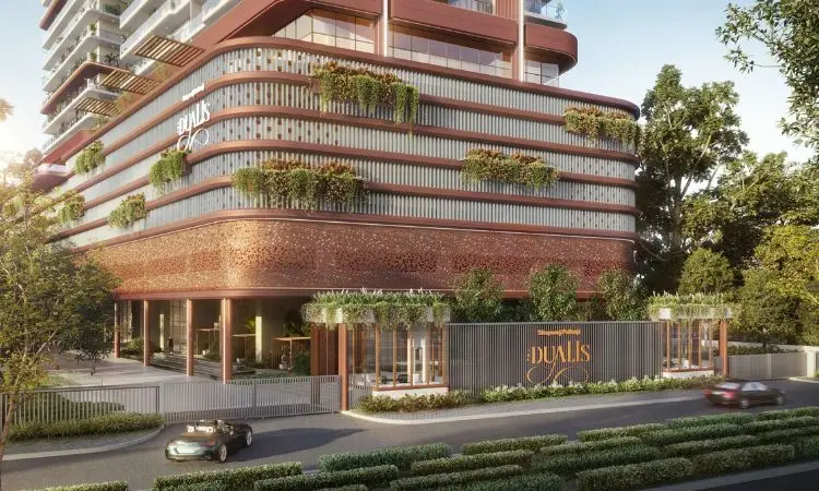 Modern building facade with greenery, signage, and a landscaped entrance on a street.