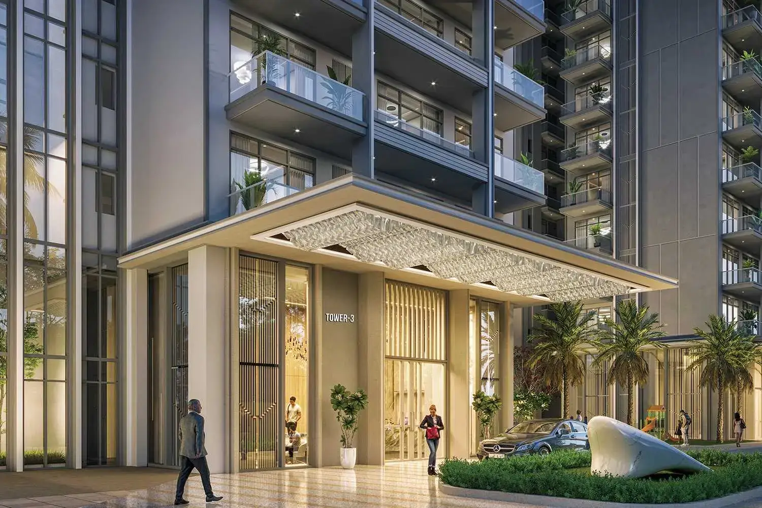 Contemporary building entrance with glass doors, palm trees, and decorative lighting.