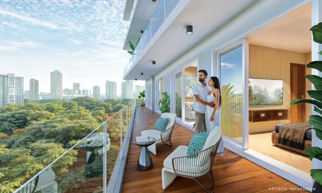 Couple standing on a balcony overlooking a city skyline with greenery below.
