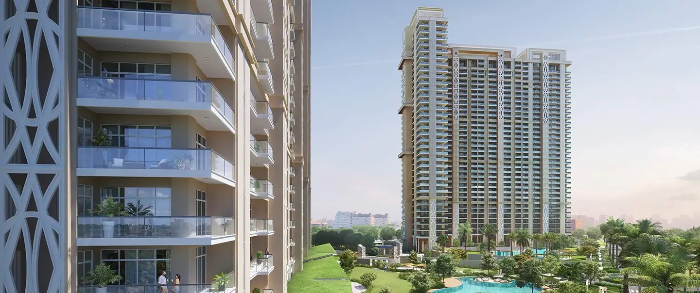 View of two residential buildings with balconies and greenery, including a swimming pool area.