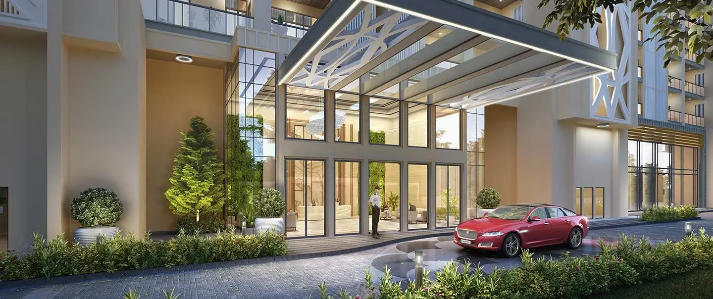 Contemporary lobby entrance with glass doors, landscaping, and a red car parked outside.