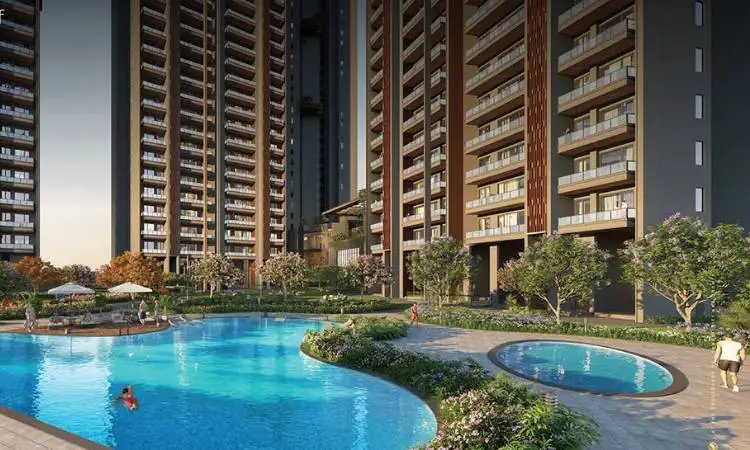 Modern residential buildings surround a large swimming pool with landscaped gardens and trees.