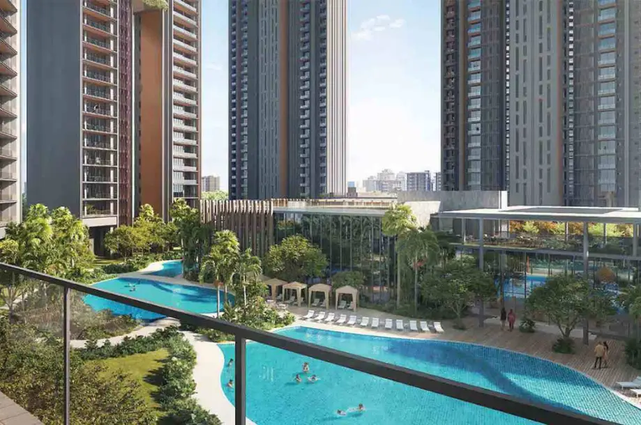 View of a swimming pool surrounded by tall buildings and lush greenery, with people enjoying the water.