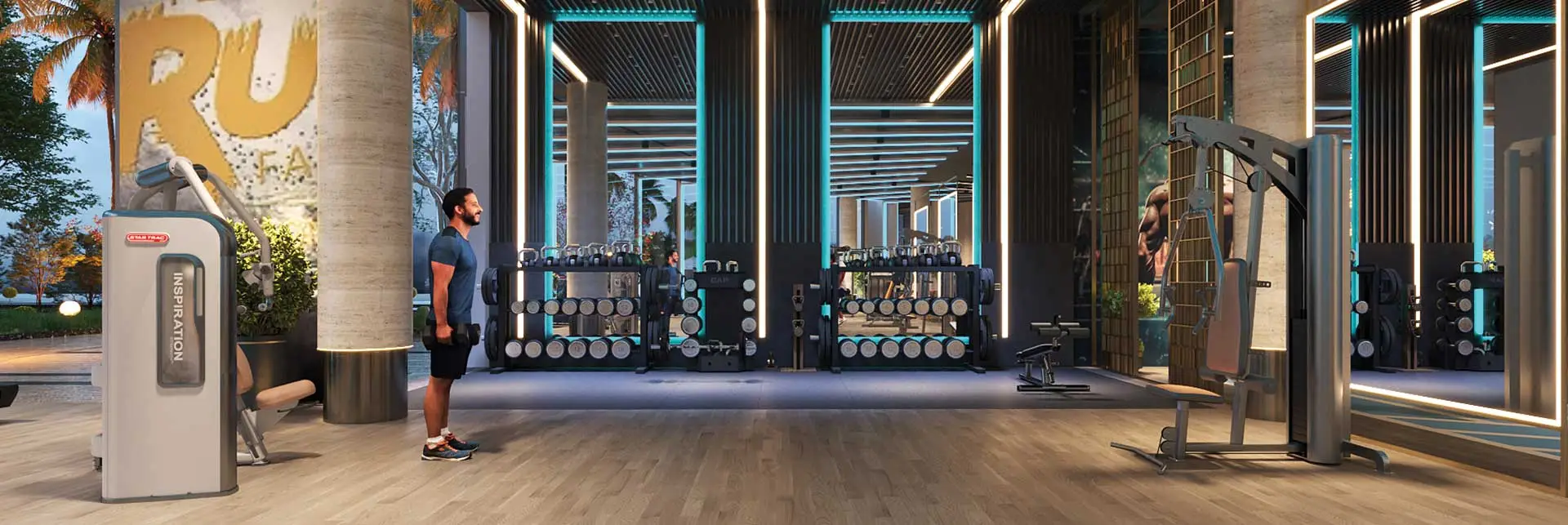 Modern gym space featuring weight machines, dumbbells, and a person standing in front of equipment.