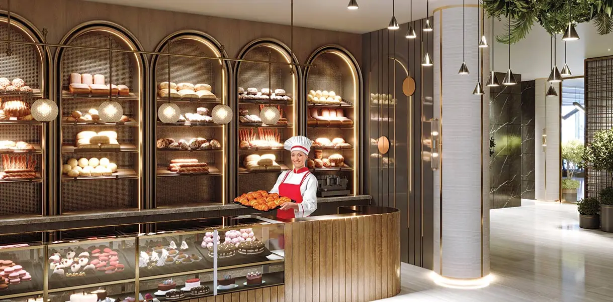 A bakery display with various pastries and a chef holding fresh croissants.