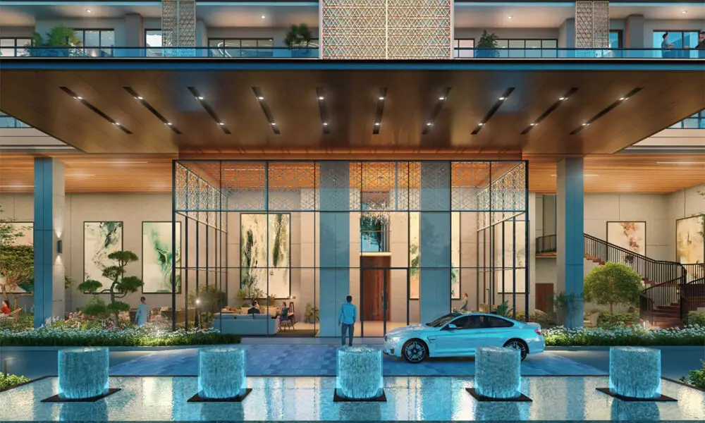 Modern building entrance with glass doors, water features, and landscaped greenery.