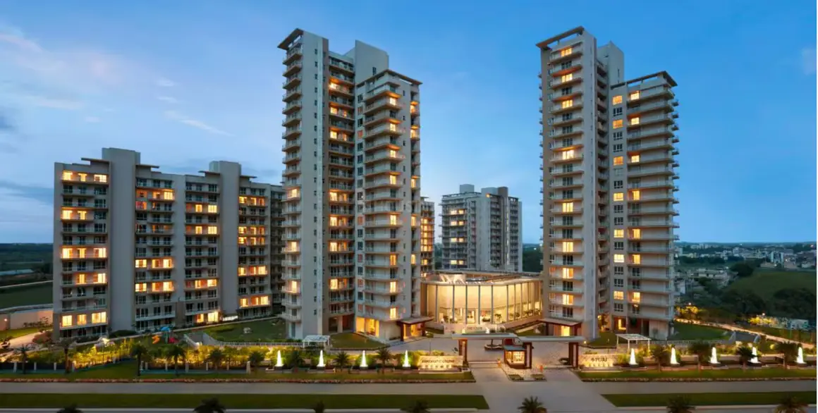 Modern residential buildings with illuminated balconies and landscaped gardens during twilight.