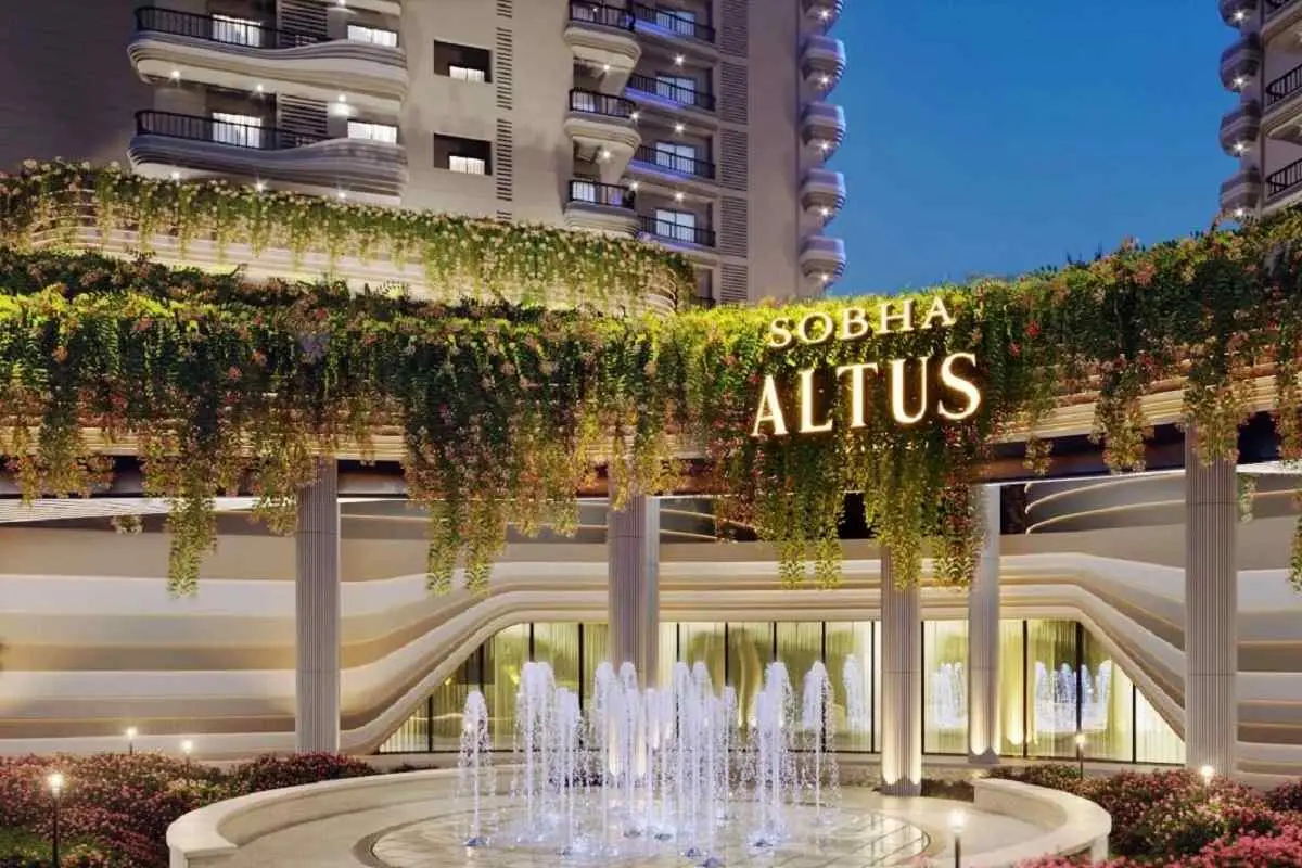 Entrance of Sobha Altus with a fountain and greenery, showcasing modern architecture at dusk.